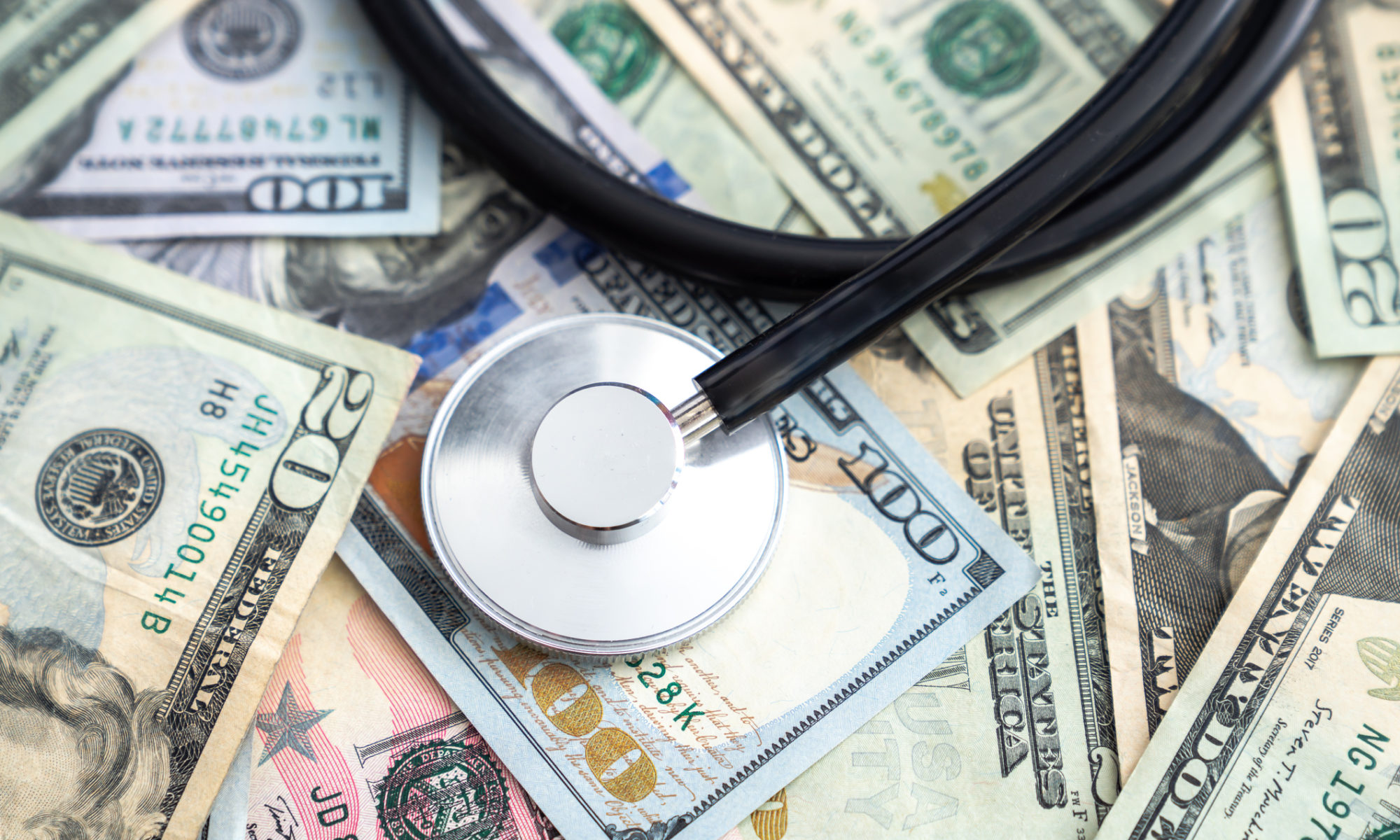 A stethoscope on a pile of money illustrates that rules around healthcare price transparency are meant to keep costs down
