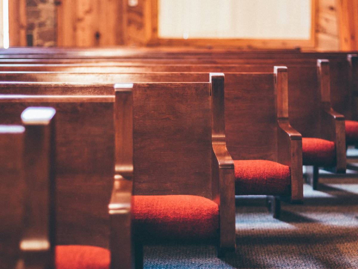 Wooden pews with red cushions illustrate the idea that churches can help to make primary care more accessible