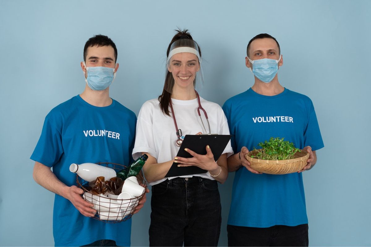 3 volunteers offering food & medicine illustrate the idea of hospital community benefit guidelines