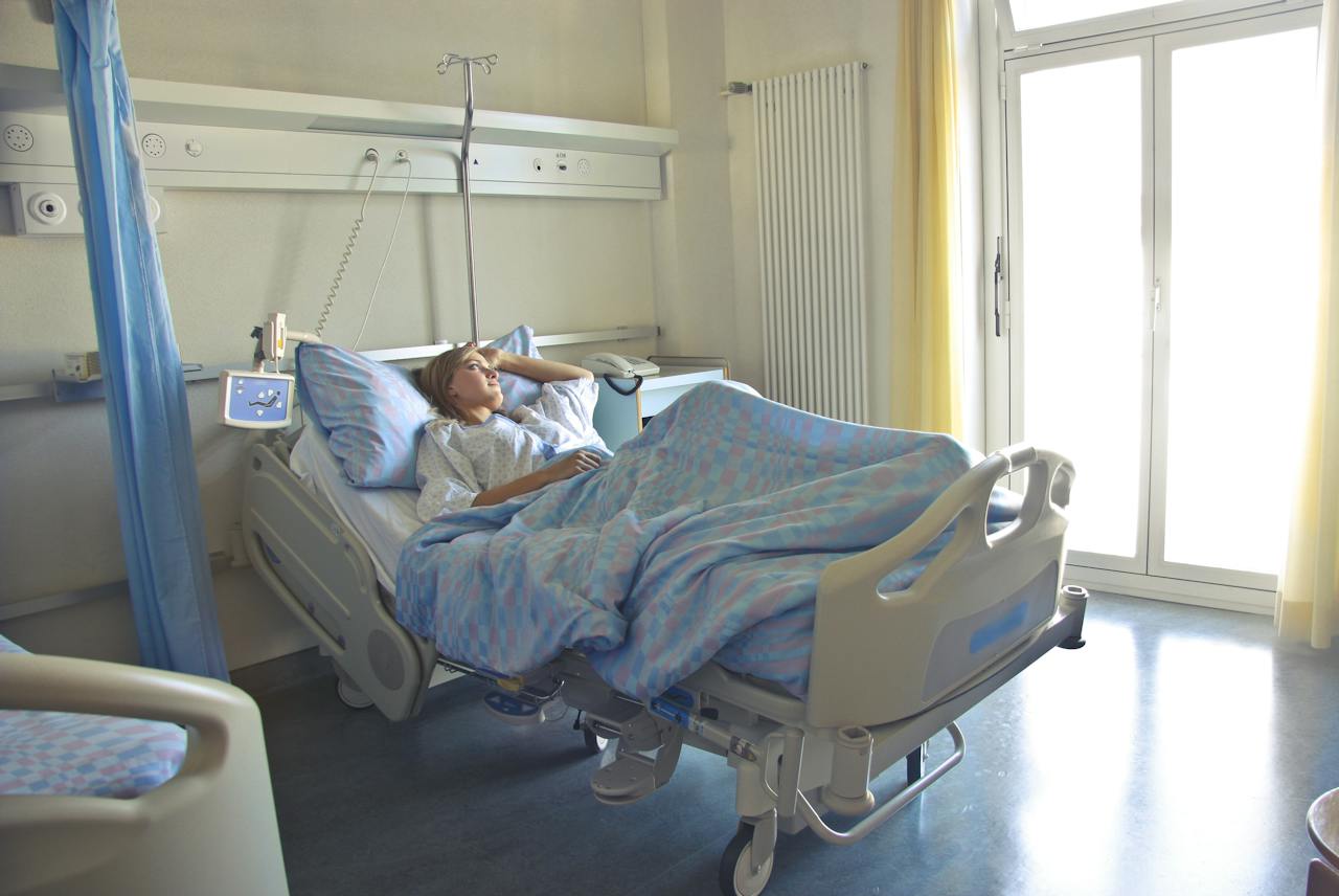 A woman lies alone in a hospital bed