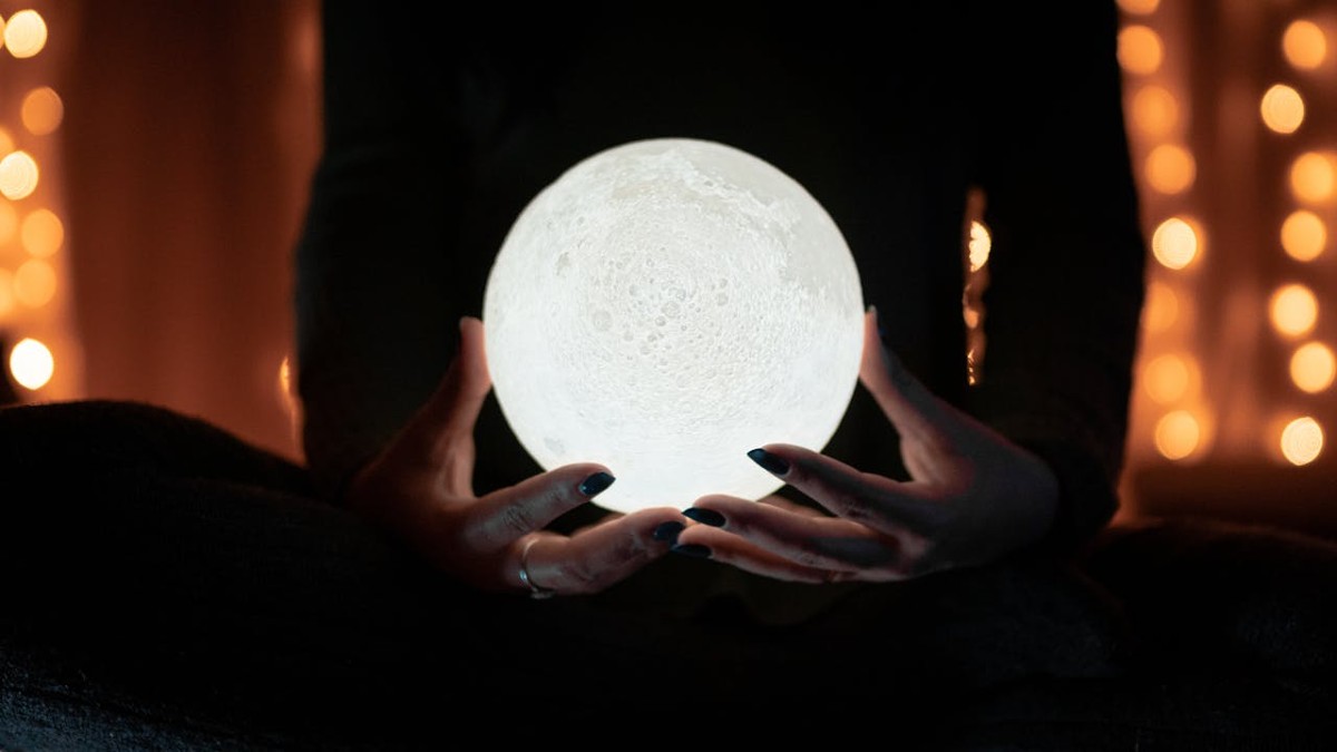 A glowing white crystal ball against a dark background